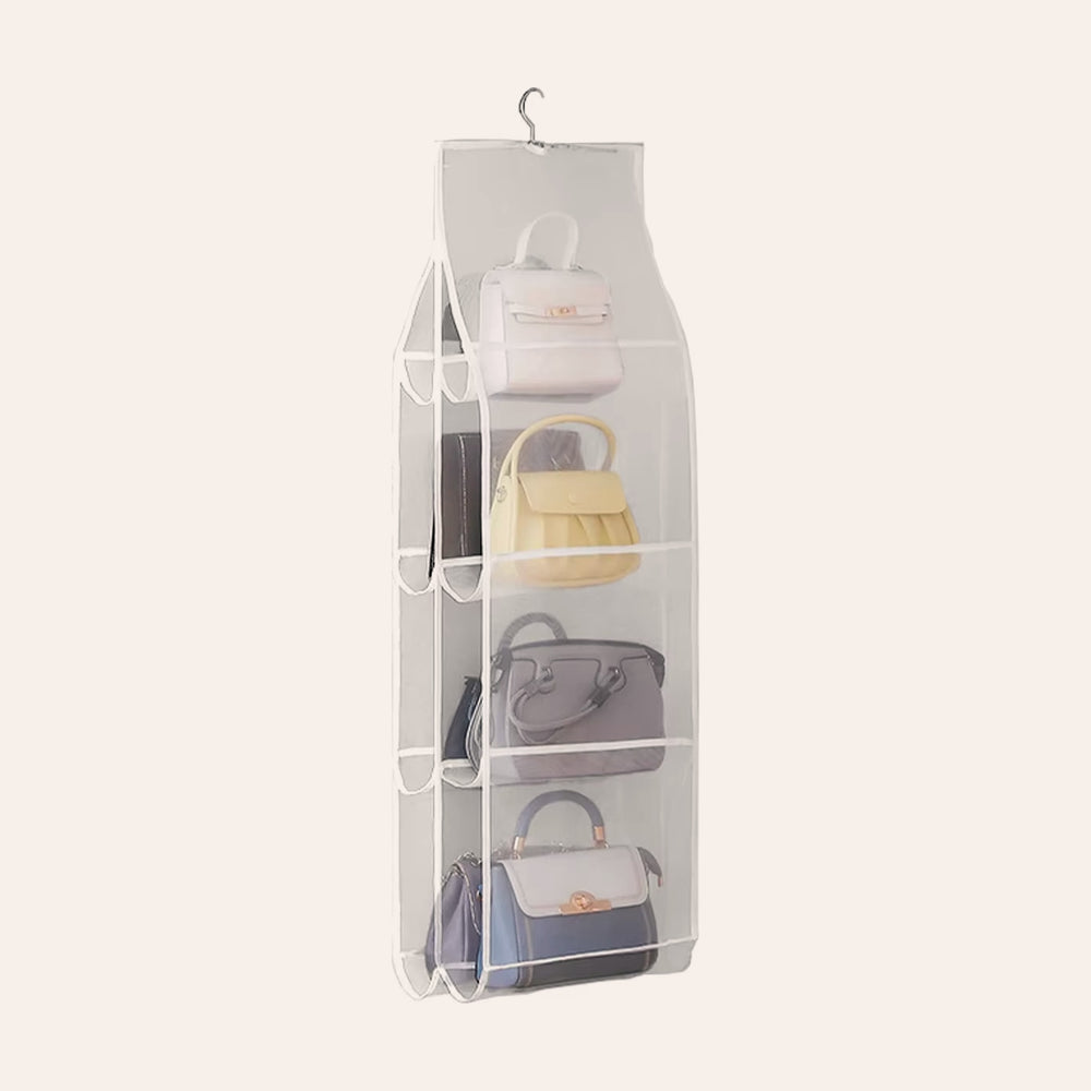 RosyIron hanging handbag organizer with eight clear mesh pockets holding handbags, on a soft blush background