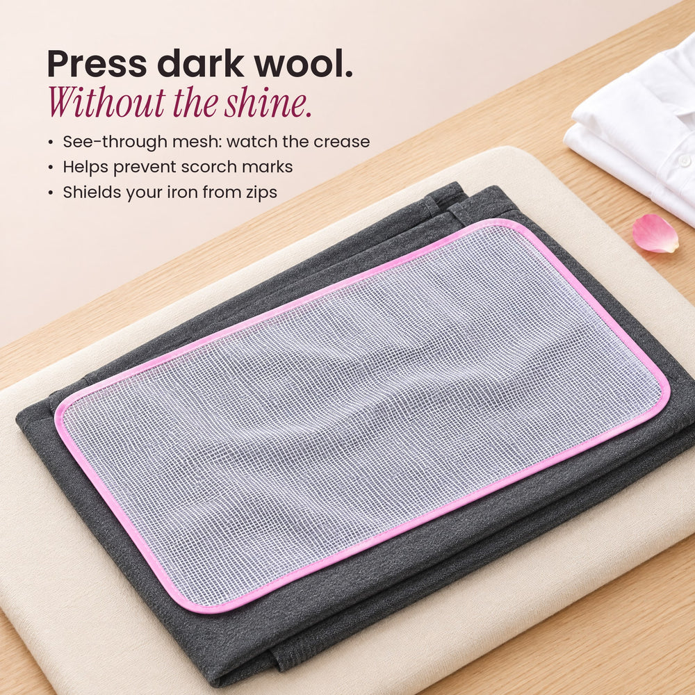 RosyIron mesh pressing cloth laid on grey wool trousers on a pressing pad, helping prevent shine when ironing