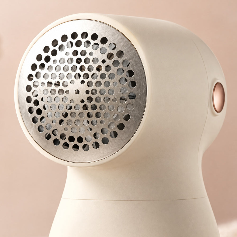 RosyIron fabric shaver close-up of the perforated stainless steel guard and rose-gold power button