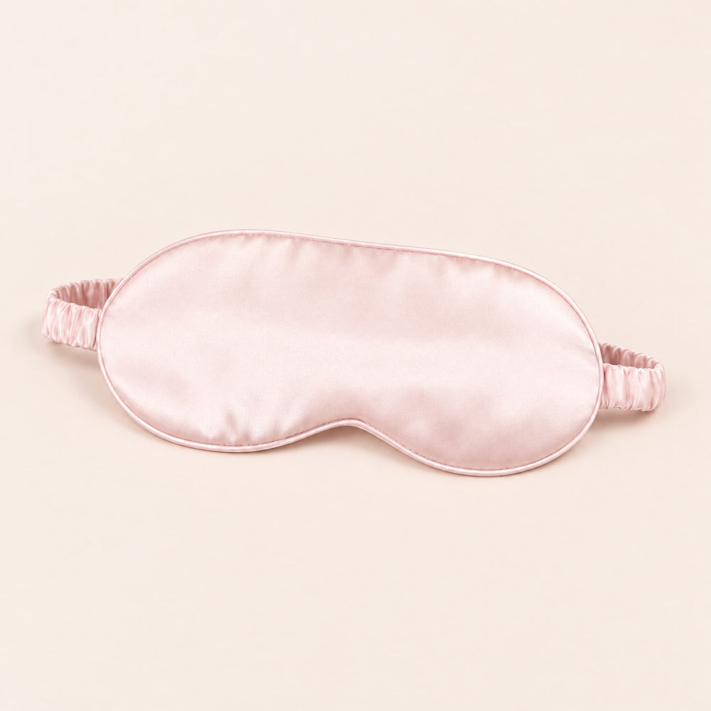 RosyIron satin sleep mask in blush pink with thin piping and gathered elastic strap on a blush-cream backdrop