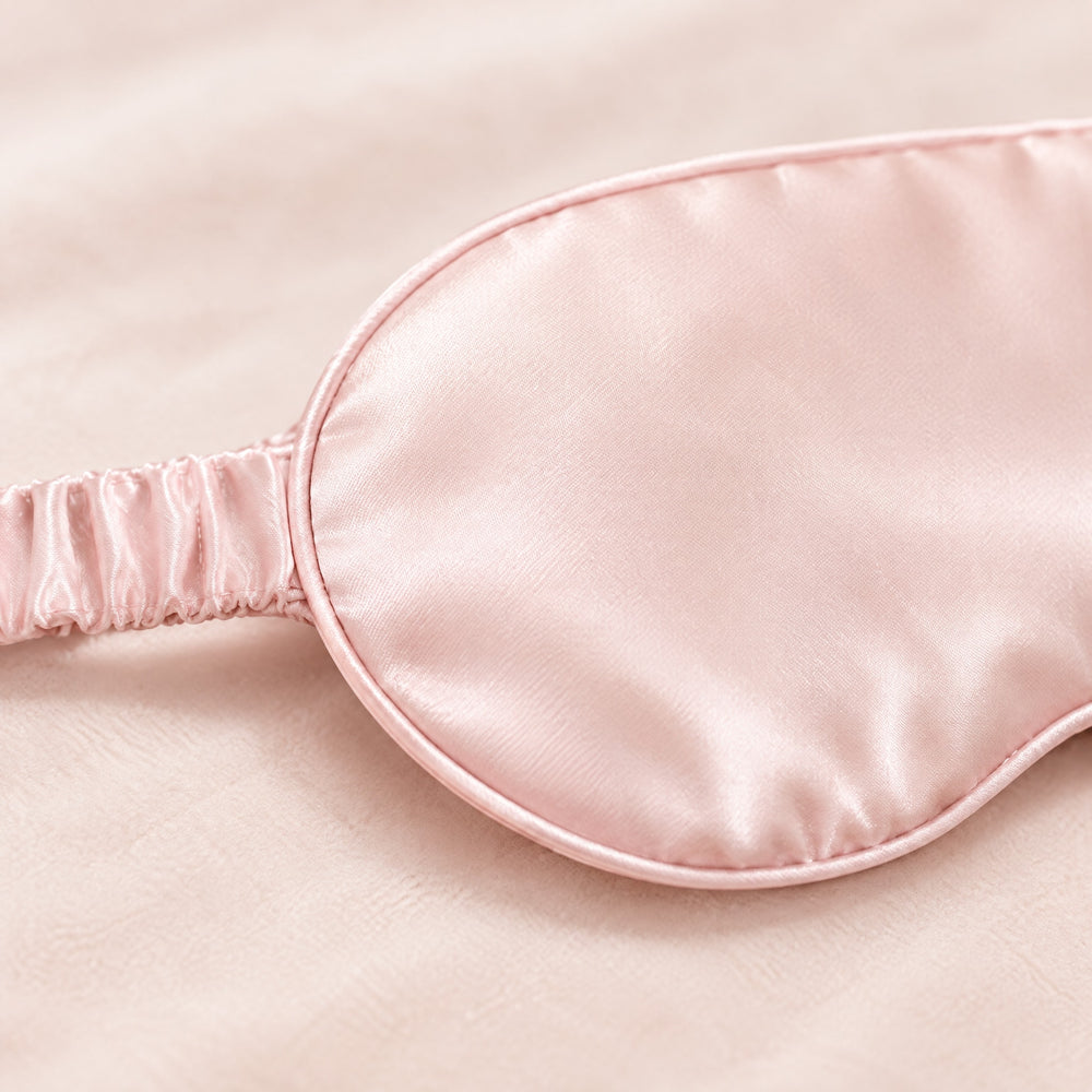 RosyIron satin sleep mask close-up showing the smooth satin sheen, matching piping and gathered elastic strap