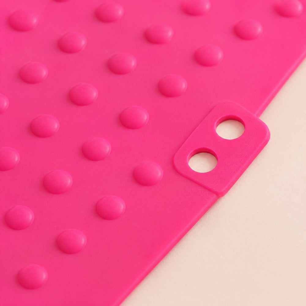 RosyIron heat resistant silicone mat close-up showing the raised silicone dots and the tab with two holes
