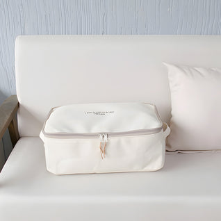 RosyIron cream canvas storage box with zipper lid resting on a light sofa