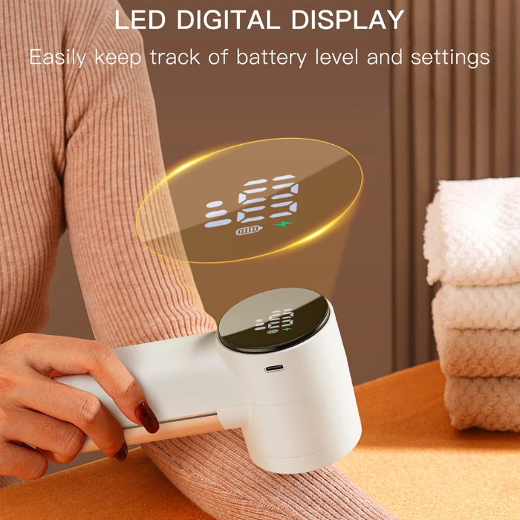 RosyIron lint remover on a beige knit sleeve, highlighting its LED digital battery display