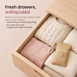 RosyIron bamboo charcoal bag lying on folded sweaters in an open wooden dresser drawer