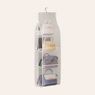 RosyIron hanging handbag organizer with eight clear mesh pockets holding handbags, on a soft blush background