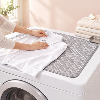 RosyIron grey quilted ironing mat on top of a washer while hands smooth a white shirt collar
