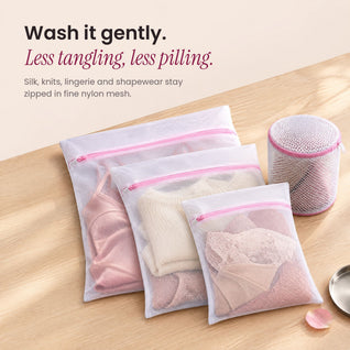 RosyIron mesh laundry bags holding a silk slip, cream knit and lace lingerie beside a cylindrical bra bag