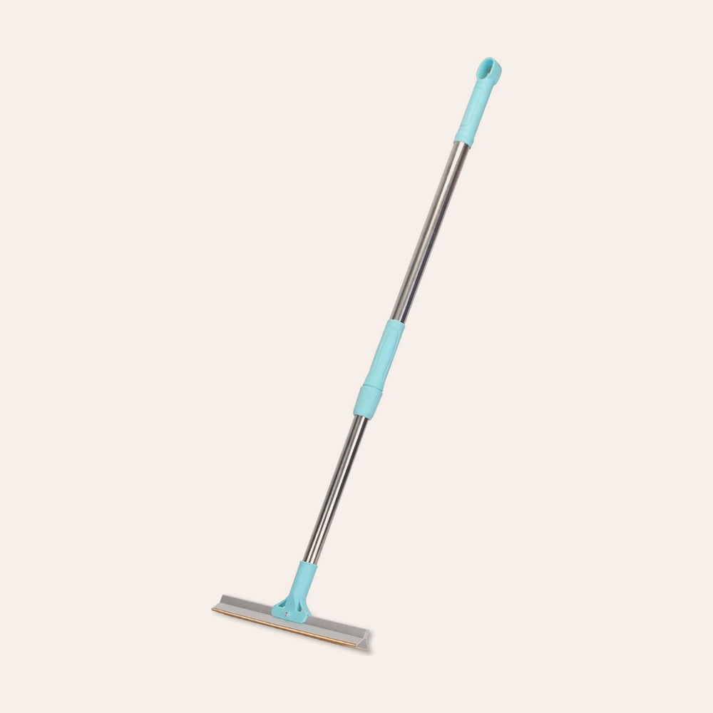 RosyIron pet hair removal rake with blue telescopic handle and copper edge head on blush background