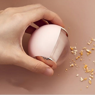 RosyIron reusable gel lint roller ball in blush pink rolling up crumbs from a surface by hand
