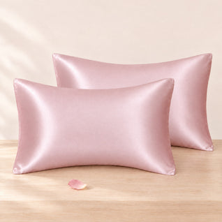 RosyIron satin pillowcases set of 2 in blush pink on Queen pillows, resting on a light wood surface