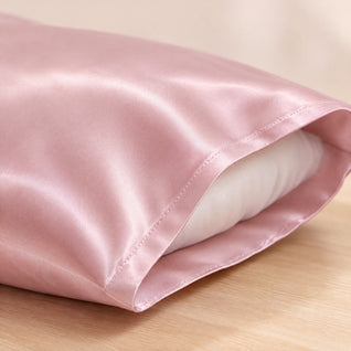 RosyIron pink satin pillowcase close-up showing the glossy polyester satin and stitched hem at the opening