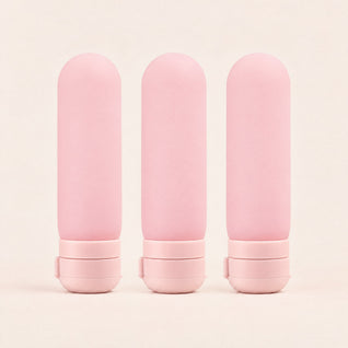 RosyIron silicone travel bottles, set of 3 pink capsule bottles standing side by side on their flip-top caps