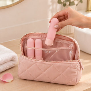 RosyIron pink silicone travel bottle held in a hand and packed into a pink quilted toiletry bag