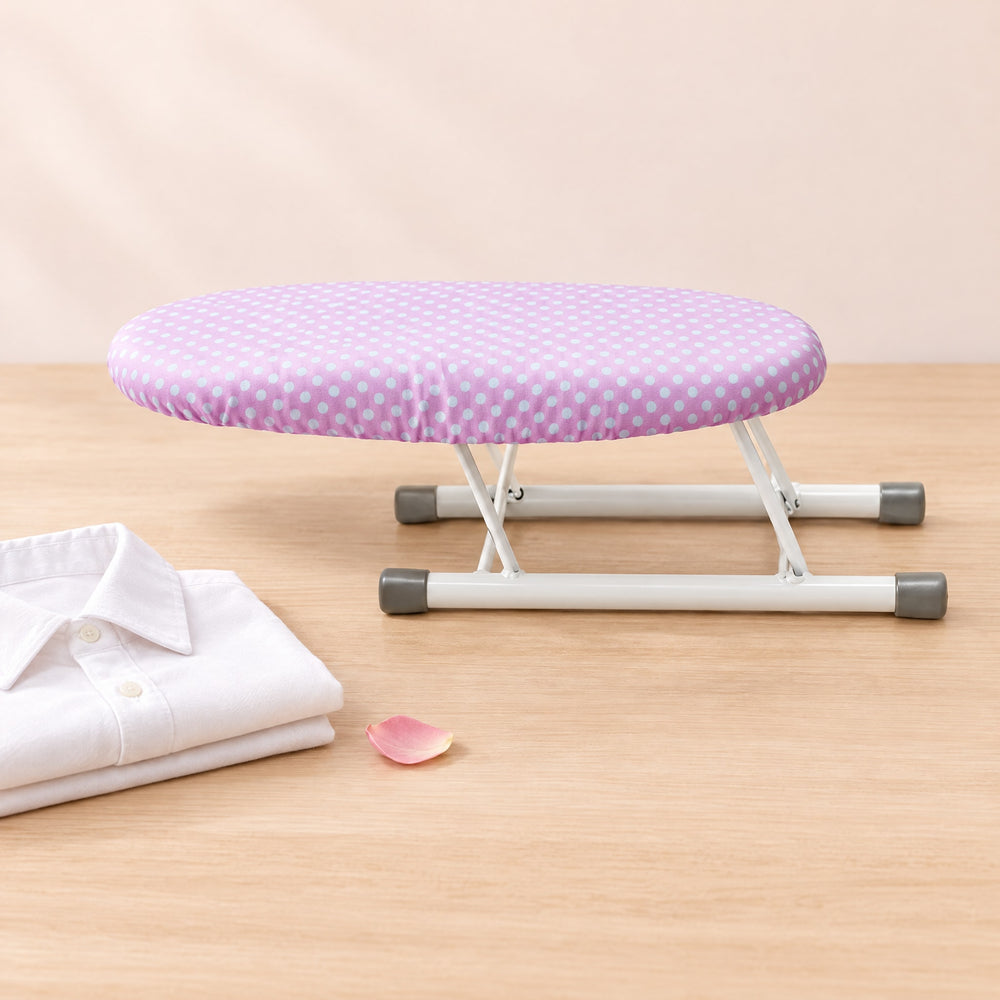 RosyIron mini sleeve ironing board with a pink polka dot cover on a light wood table