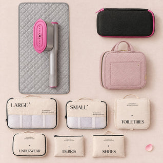 RosyIron Steam & Go Travel Set flat lay: SteamerPro on the rectangular ironing mat, travel case, pink toiletry bag and six packing cubes