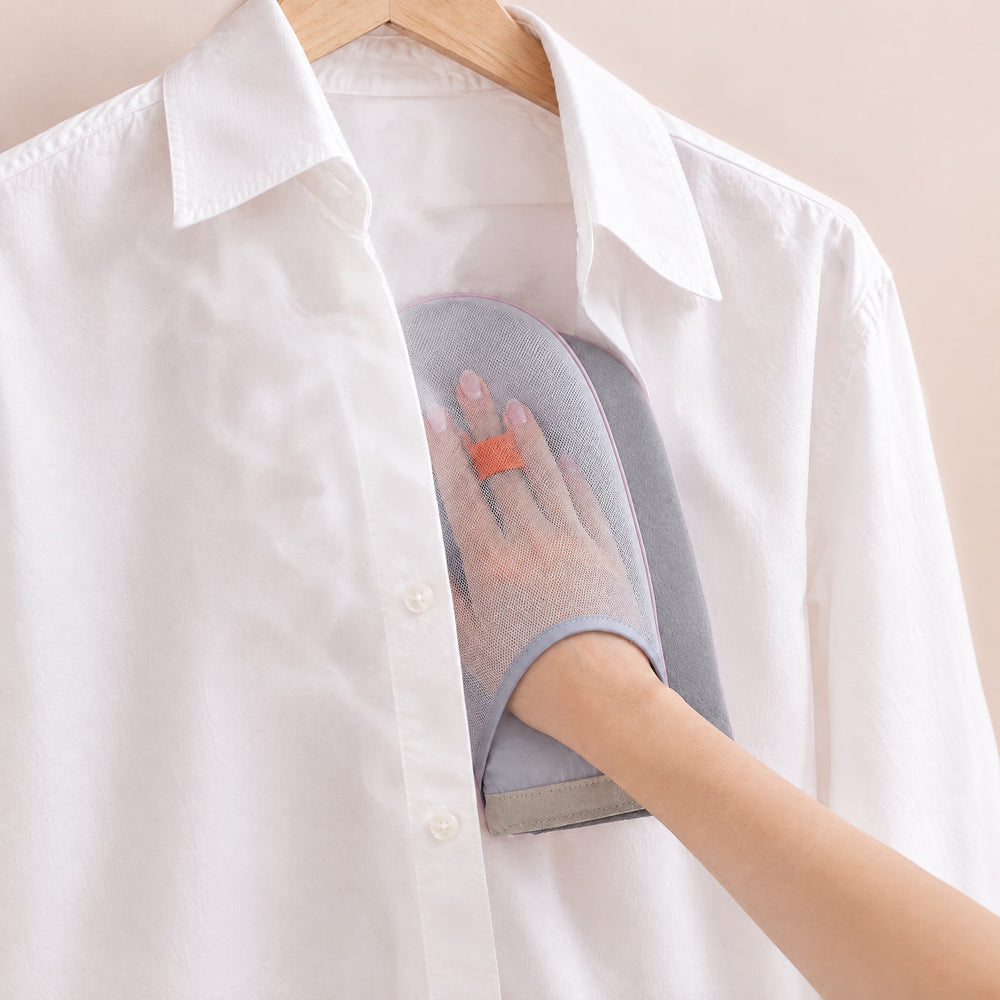 RosyIron steamer glove worn on a hand inside a hanging white dress shirt as a pressing surface