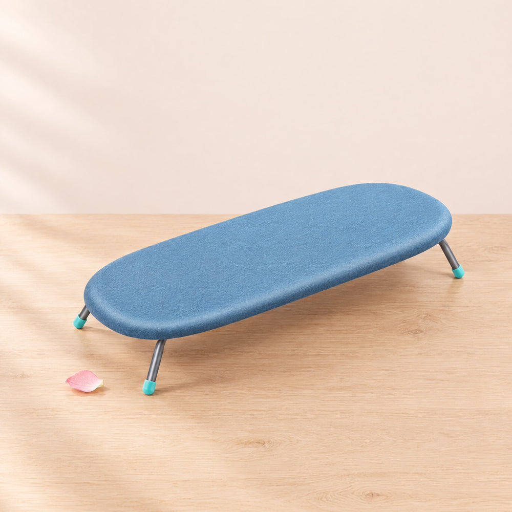 RosyIron folding tabletop ironing board with blue cover open on a light wood table