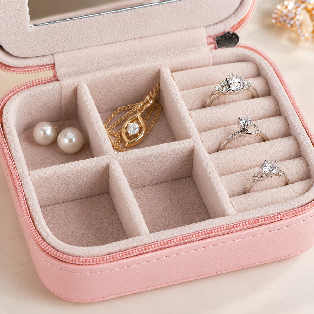 RosyIron travel jewelry case close-up of velvet ring rolls holding rings beside pearl studs and a pendant