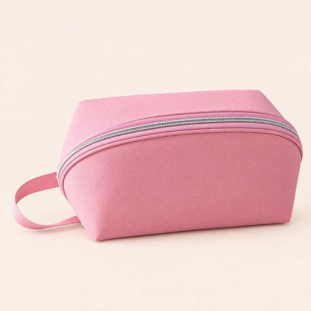 RosyIron travel lingerie pouch in blush pink, closed, with rounded body, silver zipper and loop handle