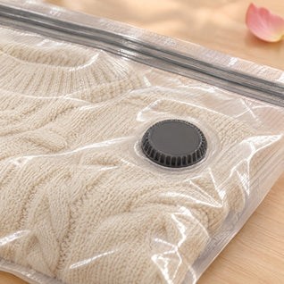 RosyIron vacuum bag close-up showing the grey air valve and double zip over a compressed cream knit sweater