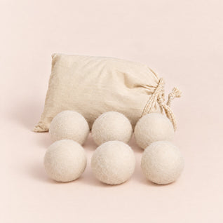 RosyIron wool dryer balls, six cream-white felted wool balls in front of a cotton drawstring bag