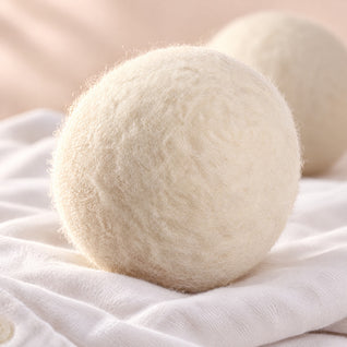 RosyIron wool dryer ball close-up showing the fine felted wool fibres on a white cotton shirt