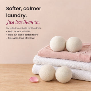 RosyIron wool dryer balls on folded towels and a pink shirt, helping reduce wrinkles and static
